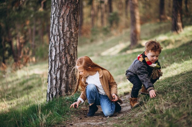 Niña con su hermano pequeño juntos en el bosque