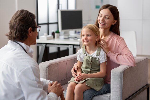 Niña con su madre en el consultorio del médico para un examen físico