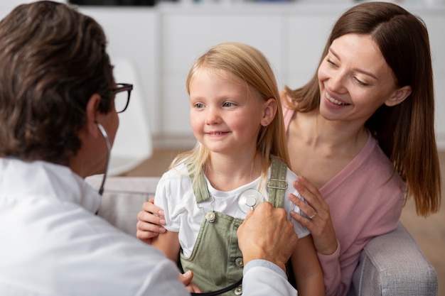 Niña con su madre en el consultorio del médico para un examen físico