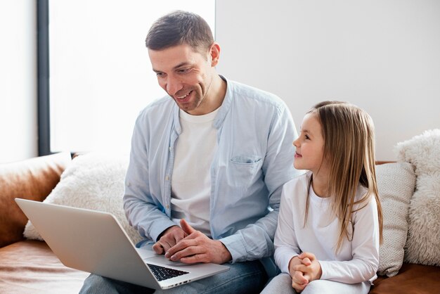 Niña y su padre pasan tiempo en la computadora portátil