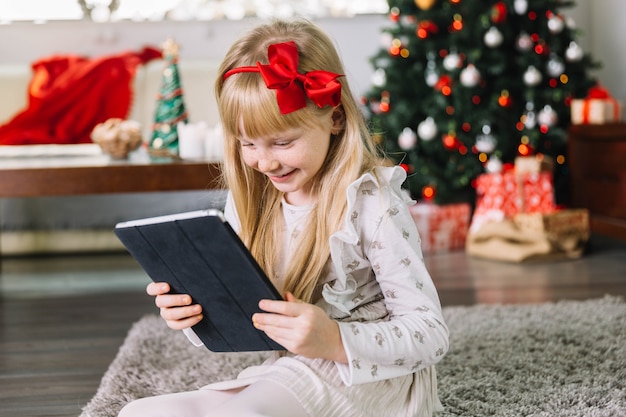 Foto gratuita niña sujetando tablet en navidad