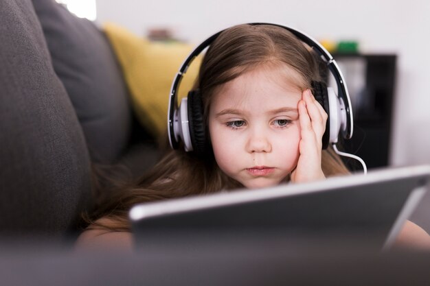 Niña con tablet en sofá