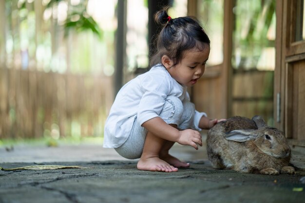 Niña tailandesa jugando con un conejo