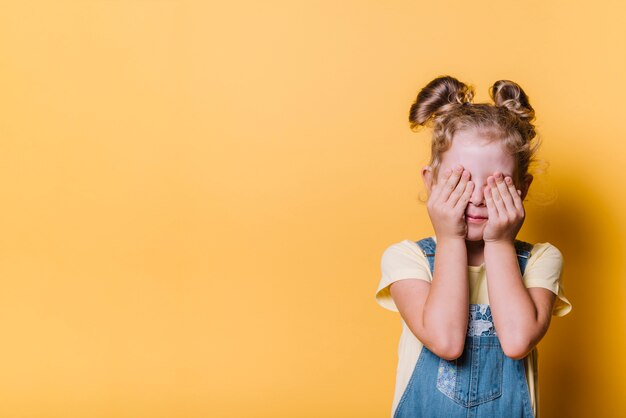 Niña tapando los ojos