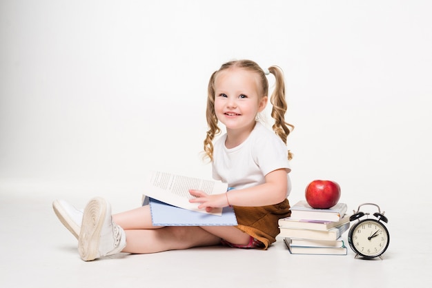 Niña tendida en el suelo y hacer dibujos en un cuaderno aislado