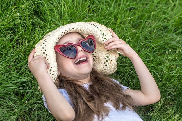 Niña tendido en el césped. horario de verano y día soleado