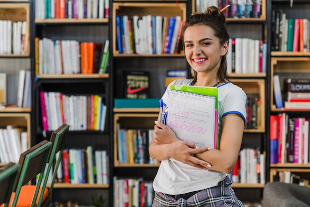 Niña, tenencia, cuadernos, pluma, sonriente