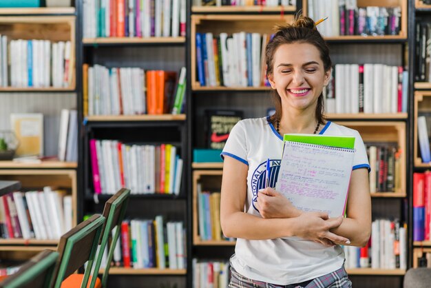 Niña, tenencia, cuadernos, pluma, sonriente