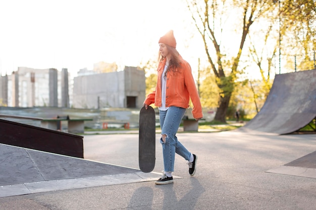 Niña, tenencia, patineta, aire libre, tiro completo