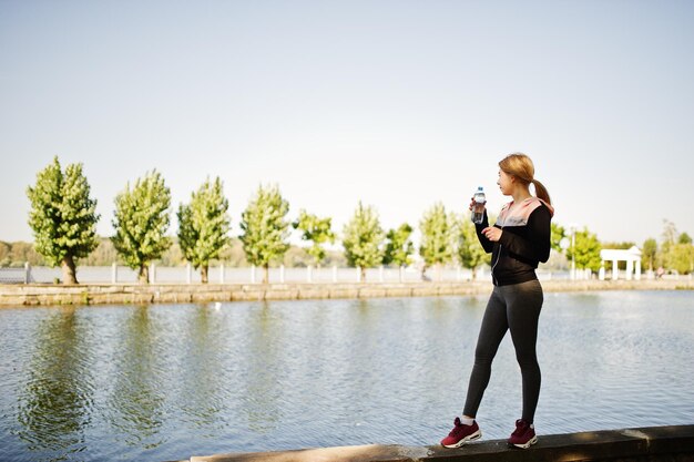 La niña tiene el entrenamiento y hace ejercicio al aire libre Concepto de entrenamiento callejero de fitness deportivo