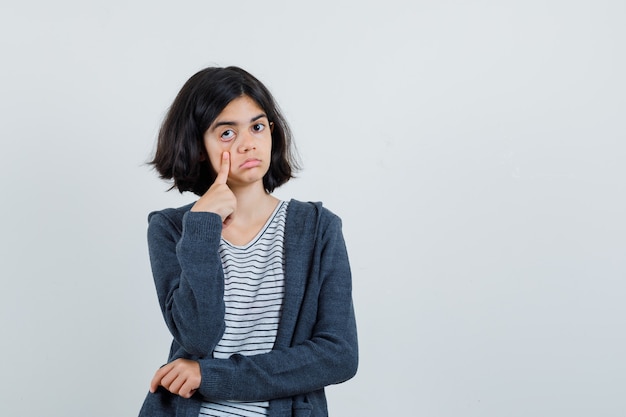 Foto gratuita niña tirando de su párpado con el dedo en camiseta