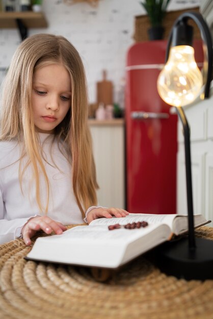 Foto gratuita niña de tiro medio leyendo la biblia