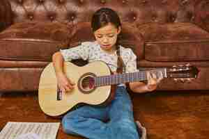 Foto gratuita niña tocando la guitarra en casa