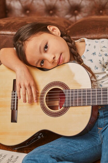 Niña tocando la guitarra en casa
