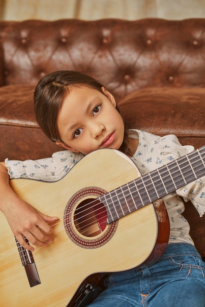 Foto gratuita niña tocando la guitarra en casa