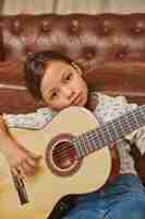 Foto gratuita niña tocando la guitarra en casa