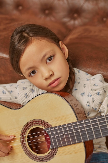 Foto gratuita niña tocando la guitarra en casa