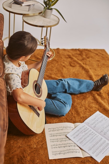 Niña tocando la guitarra en casa