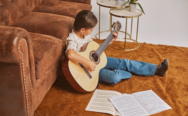 Foto gratuita niña tocando la guitarra en casa