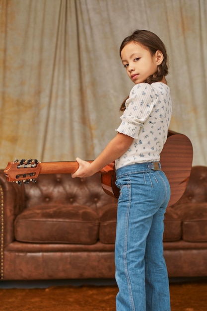 Foto gratuita niña tocando la guitarra en casa