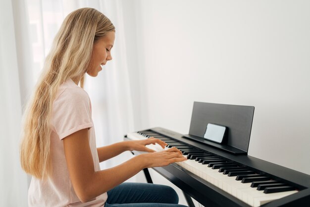 Niña tocando el instrumento de teclado en casa