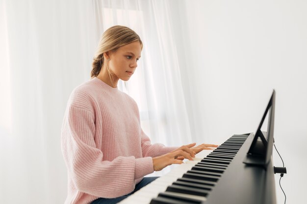 Niña tocando el instrumento de teclado en casa
