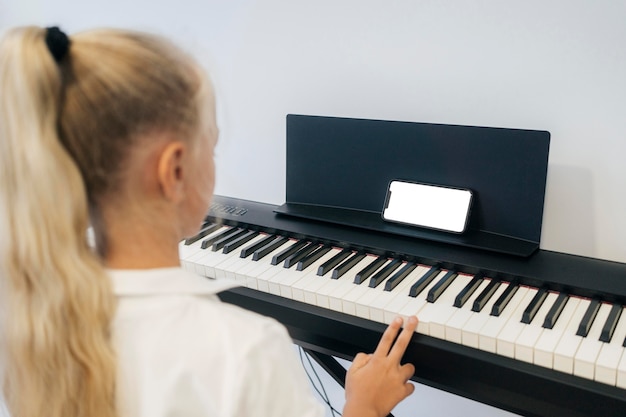 Foto gratuita niña tocando el instrumento de teclado