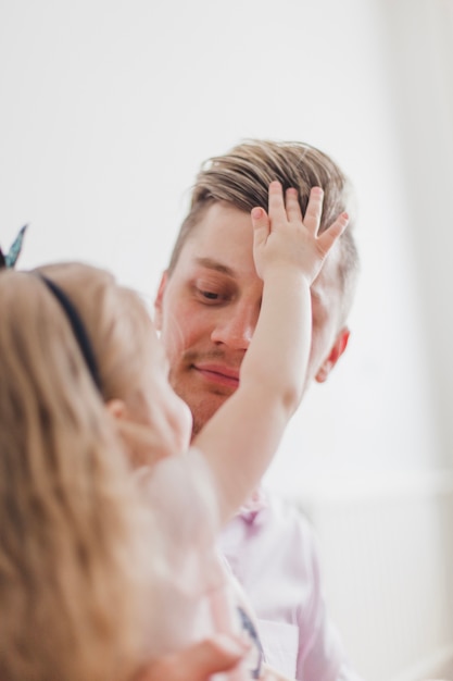 Niña tocando el pelo de su padre