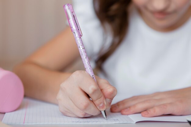 Niña tomando notas para una clase en línea