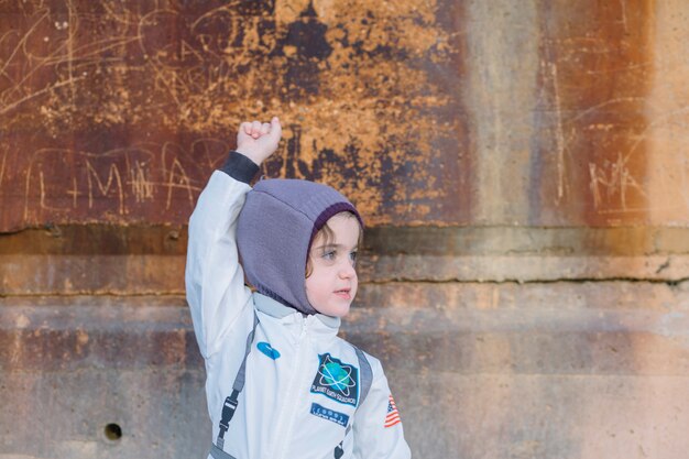 Niña en traje espacial en la pared vieja