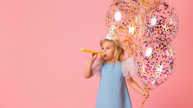 Niña en traje con globos