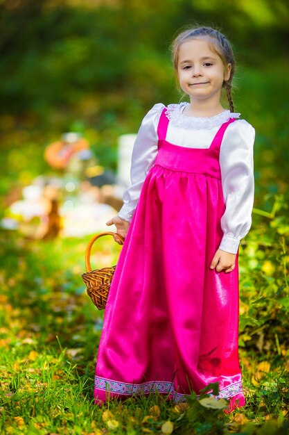 Niña en trajes de Masha de dibujos animados Masha y Bear en bosque de otoño