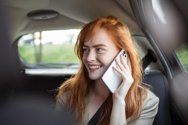 Niña usa un teléfono móvil en el automóvil Tecnología de aislamiento de teléfonos celulares Internet y redes sociales Mujer con teléfono inteligente en su automóvil Niña está usando un teléfono inteligente en el automóvil