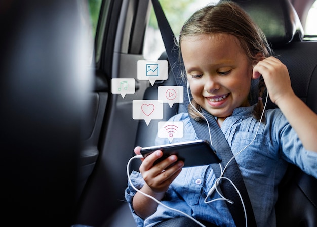 Niña usando un teléfono en un coche