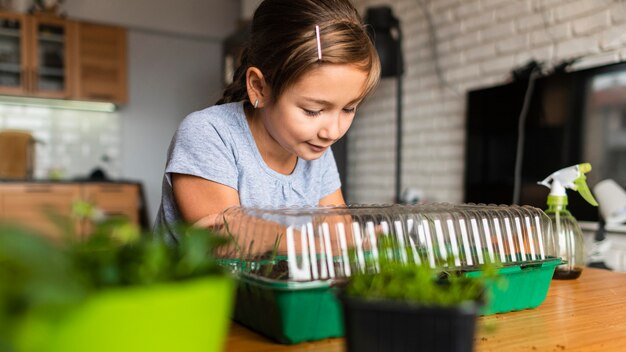 Niña viendo crecer los cultivos en casa