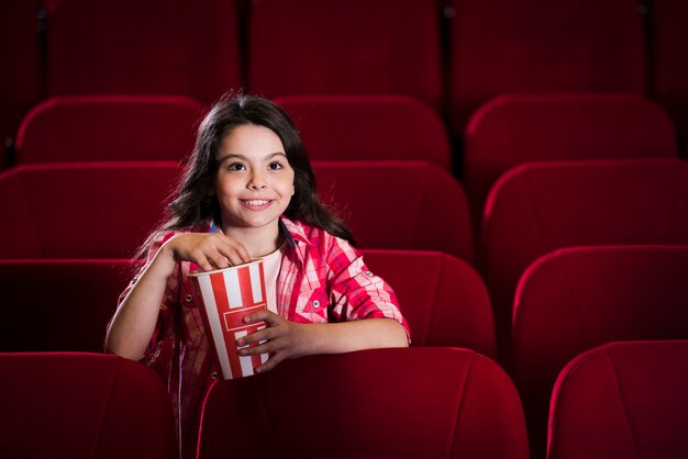 Niña viendo película en el cine