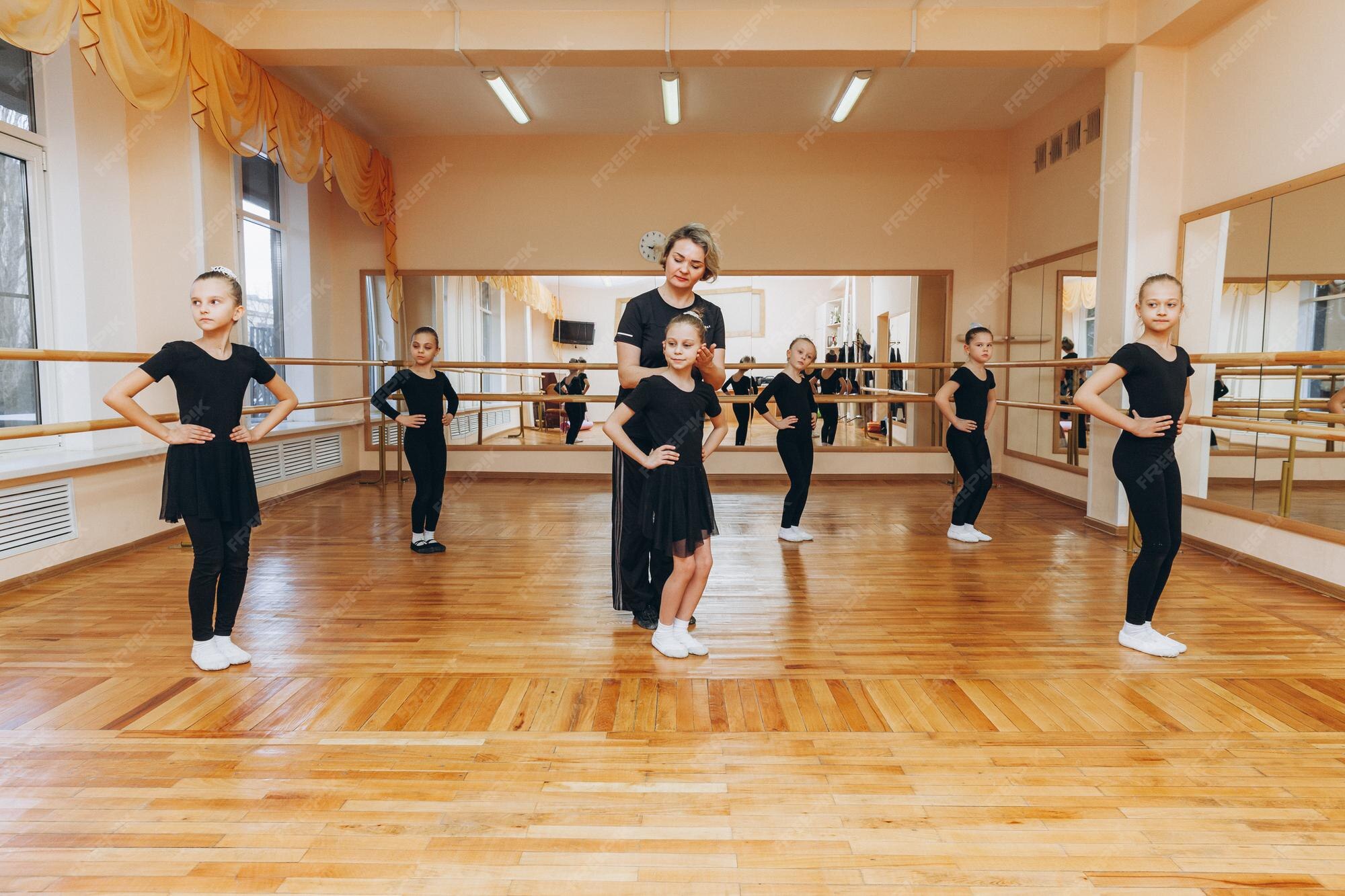 Niñas de 8 años con trajes negros están haciendo coreografías en una