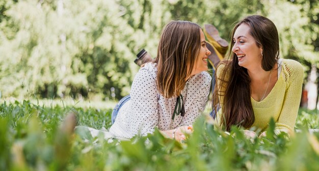 Niñas adolescentes sonrientes sentados en el césped