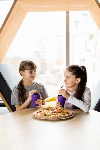 Niñas comiendo pizza