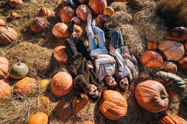 Las niñas se encuentran en un pajar entre calabazas. Vista desde arriba