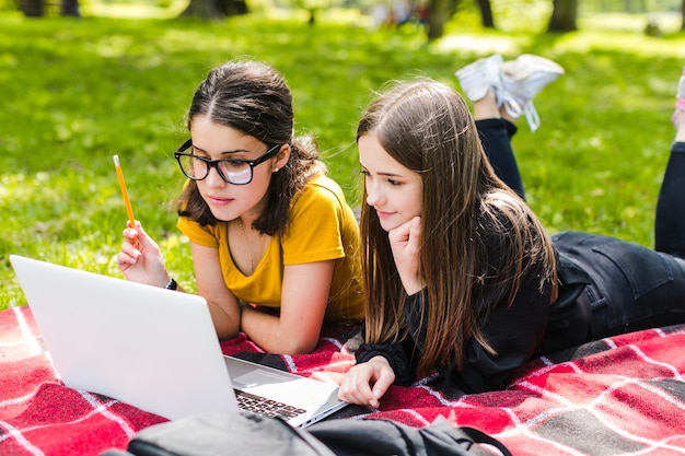 Niñas estudiando con portátil