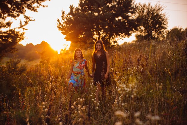 Las niñas felices caminan en el campo