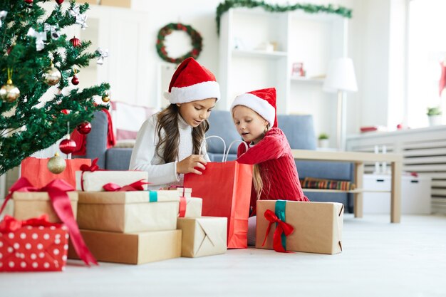 Niñas felices desenvolver regalos de Navidad