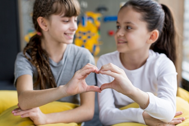 Niñas formando corazón con las manos