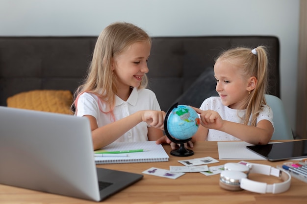 Niñas haciendo escuela en línea juntas en casa