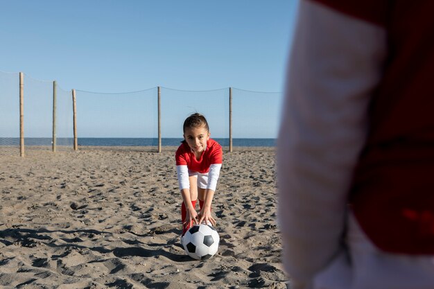 Niñas jugando al fútbol en la playa