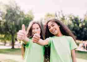 Foto gratuita niñas juguetonas gesticulando pulgar arriba signo