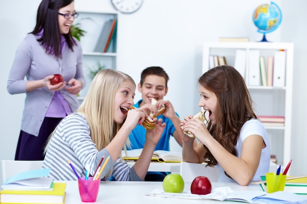 Niñas juguetonas mordiendo sus bocadillos