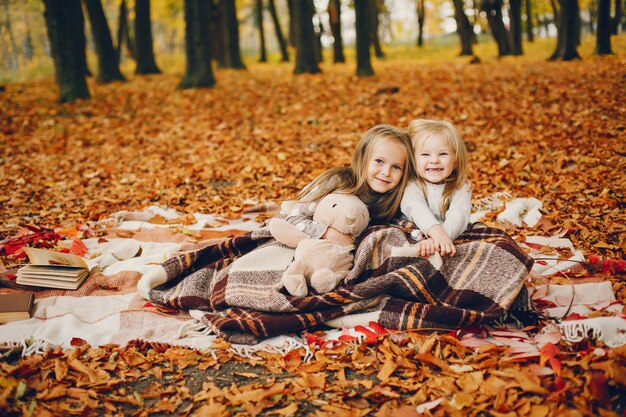 Niñas lindas en un parque de otoño