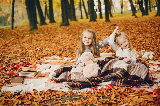 Niñas lindas en un parque de otoño